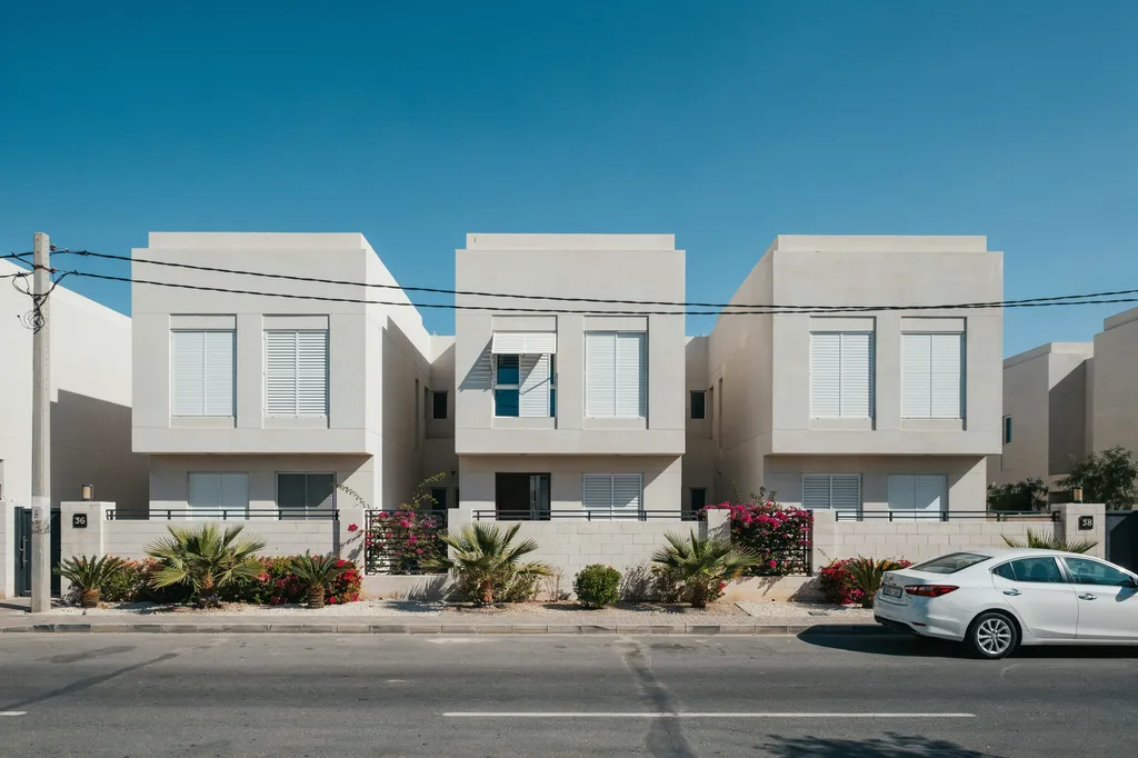 Row of modern villas in Kuwait with matching white aluminum rolling shutters installed on all windows